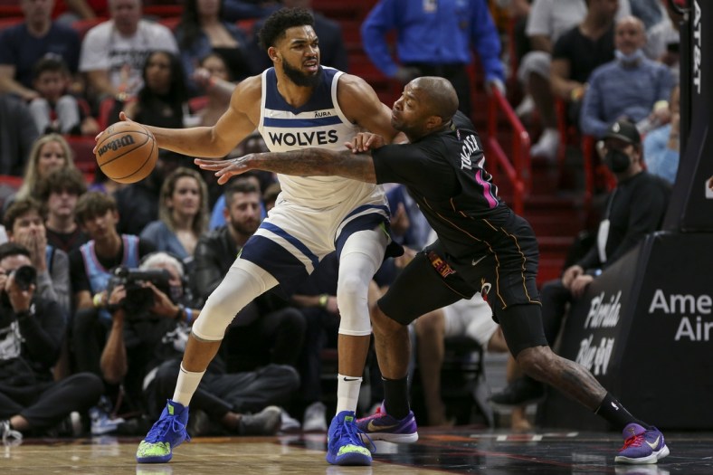 Mar 12, 2022; Miami, Florida, USA; Minnesota Timberwolves center Karl-Anthony Towns (32) protects the ball from Miami Heat forward P.J. Tucker (17) during the first quarter at FTX Arena. Mandatory Credit: Sam Navarro-USA TODAY Sports