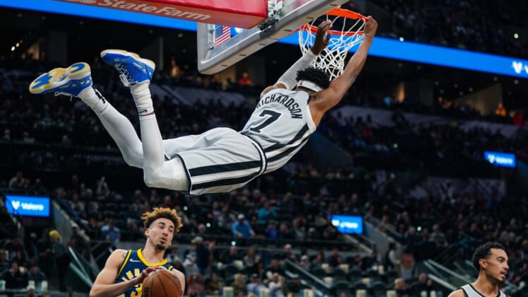 Mar 12, 2022; San Antonio, Texas, USA;  San Antonio Spurs guard Josh Richardson (7) hangs on the rim in the first half against the Indiana Pacers at the AT&T Center. Mandatory Credit: Daniel Dunn-USA TODAY Sports
