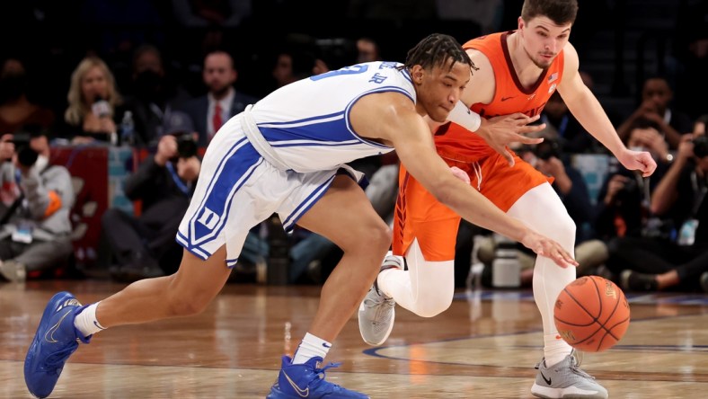 Mar 12, 2022; Brooklyn, NY, USA; Duke Blue Devils forward Wendell Moore Jr. (0) and Virginia Tech Hokies guard Hunter Cattoor (0) fight for a loose ball during the first half of the ACC Men's Basketball Tournament final at Barclays Center. Mandatory Credit: Brad Penner-USA TODAY Sports