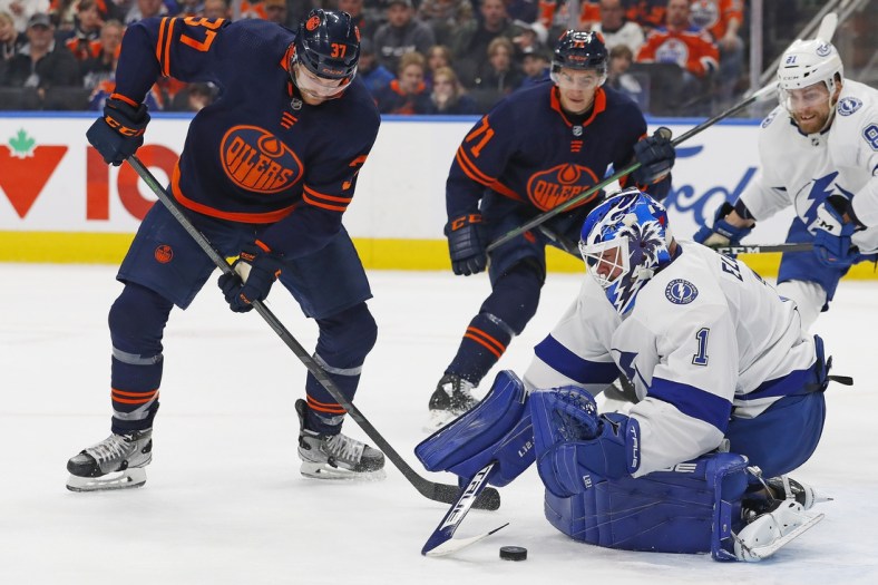 Mar 12, 2022; Edmonton, Alberta, CAN; Edmonton Oilers forward Warren Foegele (37) looks for a rebound in front of Tampa Bay Lightning goaltender Brian Elliott (1) during the first period at Rogers Place. Mandatory Credit: Perry Nelson-USA TODAY Sports