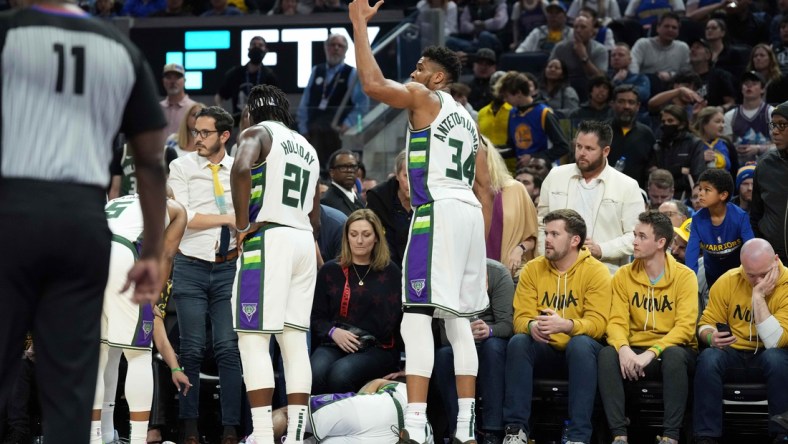 Mar 12, 2022; San Francisco, California, USA; Milwaukee Bucks forward Giannis Antetokounmpo (34) gestures as guard DeAndre' Bembry (95) lies on the floor during the third quarter at Chase Center. Mandatory Credit: Darren Yamashita-USA TODAY Sports