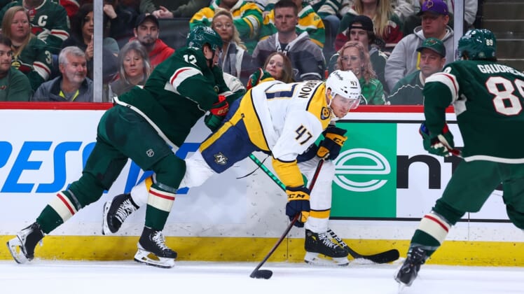 Mar 13, 2022; Saint Paul, Minnesota, USA; Nashville Predators right wing Michael McCarron (47) attempts to pass the puck as Minnesota Wild left wing Matt Boldy (12) defends him during the first period at Xcel Energy Center. Mandatory Credit: Harrison Barden-USA TODAY Sports