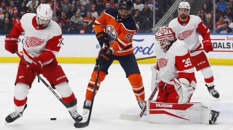 Mar 15, 2022; Edmonton, Alberta, CAN; Edmonton Oilers forward Evander Kane (91) battles for a loose puck with Detroit Red Wings defensemen Nick Leddy (2) in front of goaltender Alex Nedeljkovic (39) during the first period at Rogers Place. Mandatory Credit: Perry Nelson-USA TODAY Sports