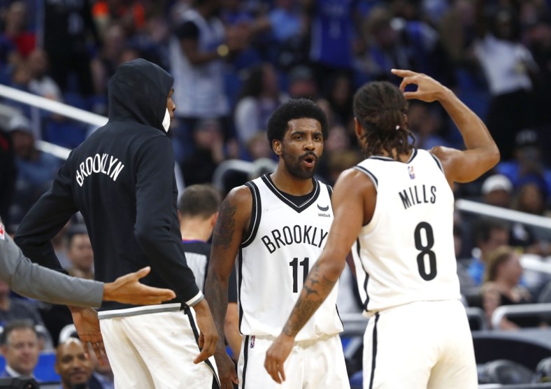 Mar 15, 2022; Orlando, Florida, USA; Brooklyn Nets guard Kyrie Irving (11) celebrates during the second half with forward Kevin Durant (7) and guard Patty Mills (8) after scoring a career high 60 points against the Orlando Magic at Amway Center. Mandatory Credit: Kim Klement-USA TODAY Sports
