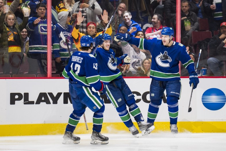 Mar 15, 2022; Vancouver, British Columbia, CAN; Vancouver Canucks defenseman Quinn Hughes (43),  forward Bo Horvat (53) and defenseman Luke Schenn (2) celebrate Horvat   s goal against the New Jersey Devils in the third period at Rogers Arena. Vancouver won 6-3. Mandatory Credit: Bob Frid-USA TODAY Sports