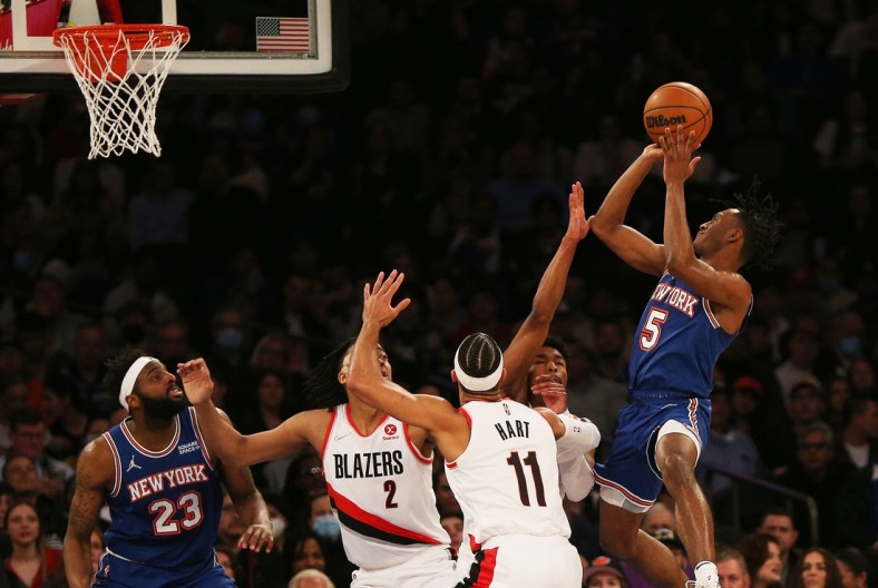Mar 16, 2022; New York, New York, USA; New York Knicks guard Immanuel Quickley (5) goes up for a shot against Portland Trail Blazers guard Josh Hart (11) and Portland Trail Blazers forward Trendon Watford (2) during the first half at Madison Square Garden. Mandatory Credit: Andy Marlin-USA TODAY Sports