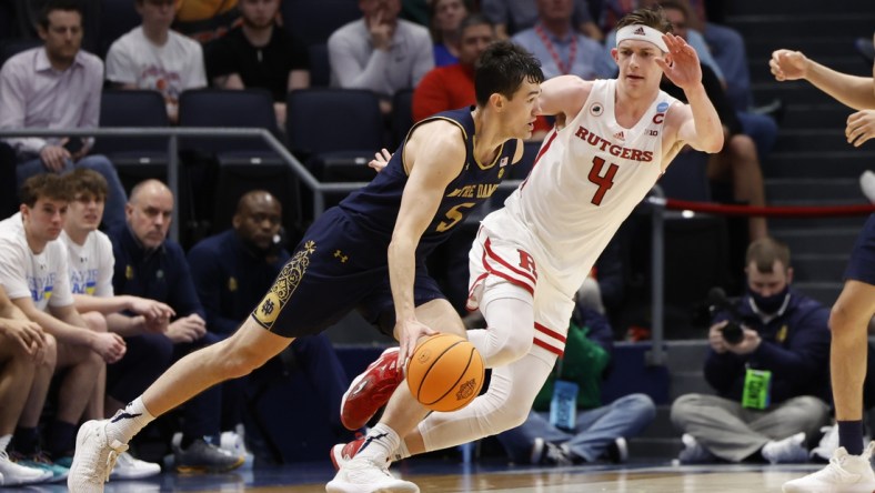 Mar 16, 2022; Dayton, Ohio, USA; Notre Dame Fighting Irish guard Cormac Ryan (5) drives to the basket defended by Rutgers Scarlet Knights guard Paul Mulcahy (4) in the second half at University of Dayton Arena. Mandatory Credit: Rick Osentoski-USA TODAY Sports