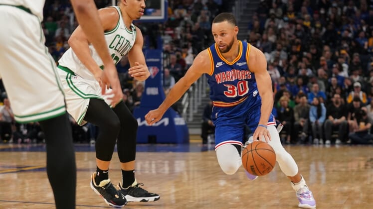 Mar 16, 2022; San Francisco, California, USA; Golden State Warriors guard Stephen Curry (30) dribbles past Boston Celtics forward Grant Williams (12) in the second quarter at the Chase Center. Mandatory Credit: Cary Edmondson-USA TODAY Sports