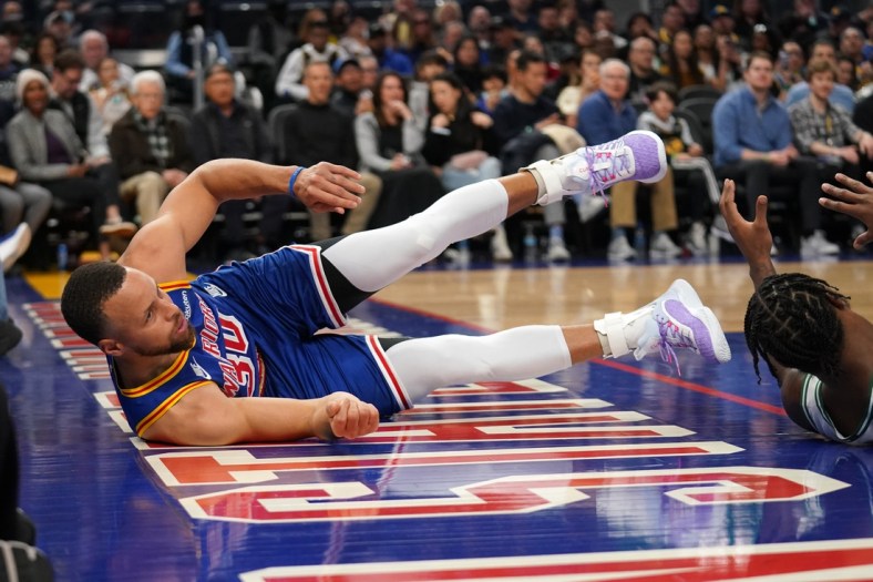 Mar 16, 2022; San Francisco, California, USA; Golden State Warriors guard Stephen Curry (30) falls on the ground after being called for an offensive foul against the Boston Celtics in the second quarter at the Chase Center. Mandatory Credit: Cary Edmondson-USA TODAY Sports