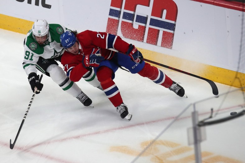 Mar 17, 2022; Montreal, Quebec, CAN; Montreal Canadiens defenseman Alexander Romanov (27) and  Dallas Stars center Tyler Seguin (91) battle for the puck during the first period at Bell Centre. Mandatory Credit: Jean-Yves Ahern-USA TODAY Sports