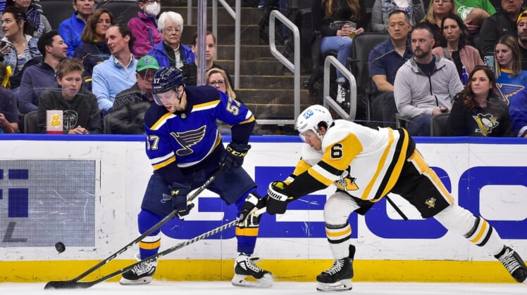 Mar 17, 2022; St. Louis, Missouri, USA;  St. Louis Blues left wing David Perron (57) and Pittsburgh Penguins defenseman John Marino (6) battle for the puck during the first period at Enterprise Center. Mandatory Credit: Jeff Curry-USA TODAY Sports