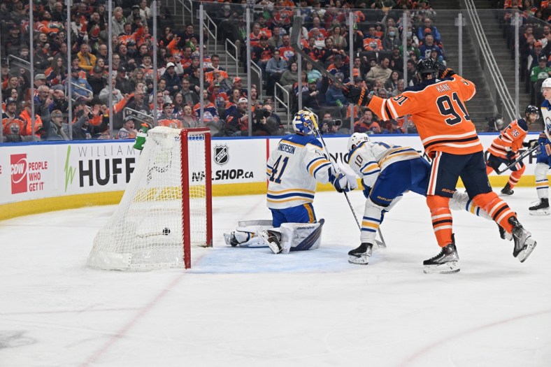 Mar 17, 2022; Edmonton, Alberta, CAN;  Buffalo Sabres goalie Craig Anderson (41) looks on as the the puck streaks past him as Sabres defenceman Henri Jokiharju (10) skates past as Edmonton Oilers left winger Evnder Kane (91) looks on during the first period at Rogers Place. Mandatory Credit: Walter Tychnowicz-USA TODAY Sports
