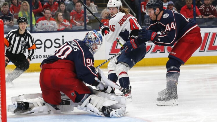 Mar 17, 2022; Columbus, Ohio, USA; Washington Capitals left wing Axel Jonsson-Fjallby (45) shoots as Columbus Blue Jackets goalie Elvis Merzlikins (90) makes a save during the third period at Nationwide Arena. Mandatory Credit: Russell LaBounty-USA TODAY Sports