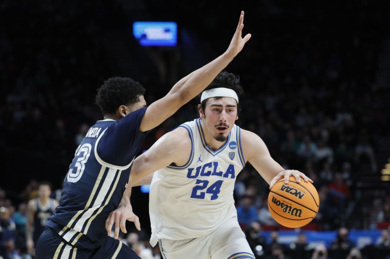 Mar 17, 2022; Portland, OR, USA; UCLA Bruins guard Jaime Jaquez Jr. (24) dribbles the basketball against Akron Zips guard Xavier Castaneda (13) during the second half during the first round of the 2022 NCAA Tournament at Moda Center. Mandatory Credit: Soobum Im-USA TODAY Sports