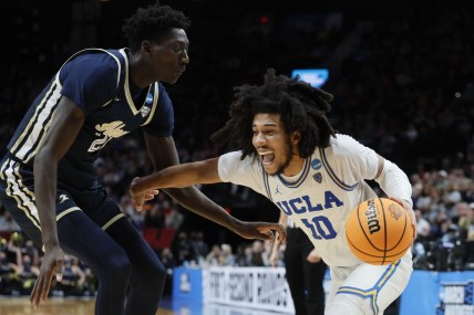 Mar 17, 2022; Portland, OR, USA; UCLA Bruins guard Tyger Campbell (10) dribbles the basketball against Akron Zips center Aziz Bandaogo (21) during the second half during the first round of the 2022 NCAA Tournament at Moda Center. Mandatory Credit: Soobum Im-USA TODAY Sports