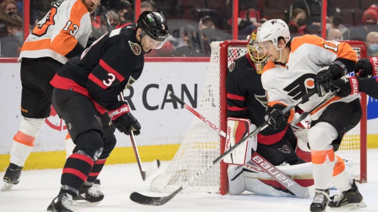 Mar 18, 2022; Ottawa, Ontario, CAN; Philadelphia Flyers right wing Travis Konecny (11) moves in on Ottawa Senators defenseman Josh Brown (3) in the first period at the Canadian Tire Centre. Mandatory Credit: Marc DesRosiers-USA TODAY Sports