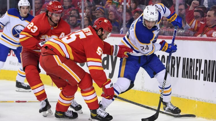 Mar 18, 2022; Calgary, Alberta, CAN; Calgary Flames defenseman Noah Hanifin (55) and Buffalo Sabres forward Dylan Cozens (24) battle for the puck in the second period at Scotiabank Saddledome. Mandatory Credit: Candice Ward-USA TODAY Sports