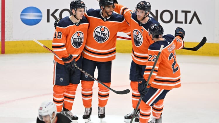 Mar 19, 2022; Edmonton, Alberta, CAN;   Edmonton Oilers left winger Zach Hyman (18) celebrates with left winger Evander Kane (91) and center Connor McDavid (97) and defenseman Tyson Barrie (22) after a goal against the New Jersey Devils during the third period at Rogers Place. The Oilers won 6-3. Mandatory Credit: Walter Tychnowicz-USA TODAY Sports