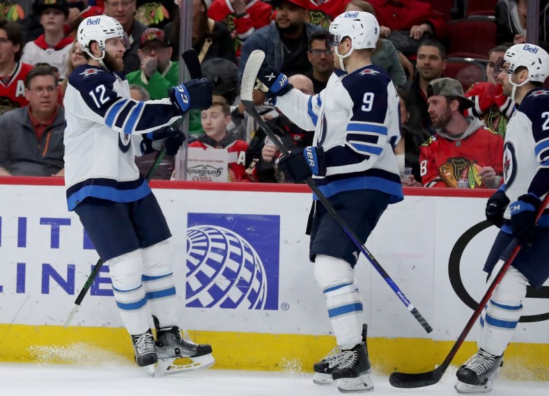 Mar 20, 2022; Chicago, Illinois, USA;Winnipeg Jets center Jansen Harkins (12) is congratulated for scoring a goal during the second period against the Chicago Blackhawks at the United Center. Mandatory Credit: Dennis Wierzbicki-USA TODAY Sports