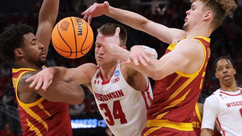 Mar 20, 2022; Milwaukee, WI, USA; Wisconsin Badgers guard Brad Davison (34) drives between Iowa State Cyclones guard Izaiah Brockington (left) and forward Aljaz Kunc (right) in the second half  during the second round of the 2022 NCAA Tournament at Fiserv Forum. Mandatory Credit: Mark Hoffman/Milwaukee Journal Sentinel via USA TODAY NETWORK