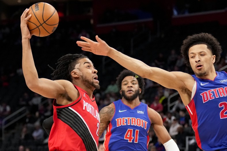 Mar 21, 2022; Detroit, Michigan, USA; Portland Trail Blazers forward Trendon Watford (2) goes up for a shot against Detroit Pistons guard Cade Cunningham (2) during the first quarter at Little Caesars Arena. Mandatory Credit: Raj Mehta-USA TODAY Sports