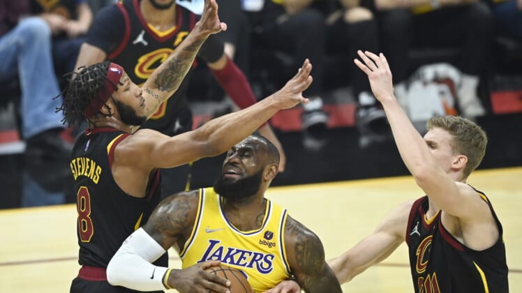 Mar 21, 2022; Cleveland, Ohio, USA; Los Angeles Lakers forward LeBron James (6) drives between Cleveland Cavaliers forward Lamar Stevens (8) and forward Lauri Markkanen (24) in the first quarter at Rocket Mortgage FieldHouse. Mandatory Credit: David Richard-USA TODAY Sports
