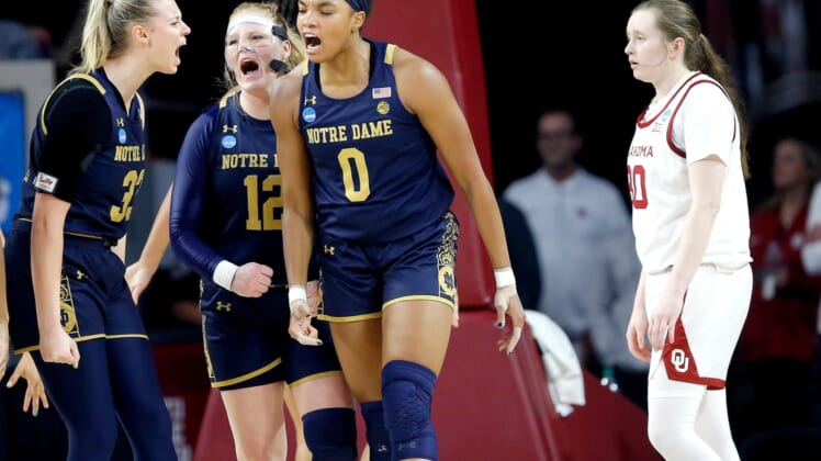 Notre Dame's Sam Brunelle (33), Abby Prohaska (12) and Maya Dodson (0) celebrate next to Oklahoma's Taylor Robertson (30) in the first half of a 108-64 win Monday in the second round of the NCAA Tournament at Lloyd Noble Center in Norman.COVER MAIN