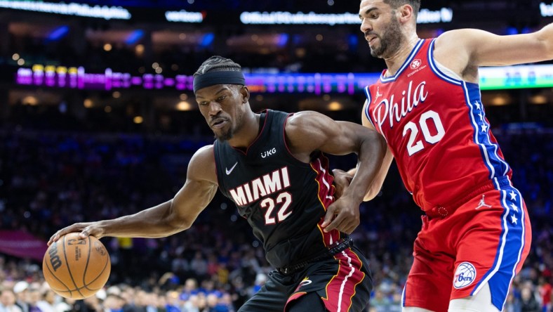 Mar 21, 2022; Philadelphia, Pennsylvania, USA; Miami Heat forward Jimmy Butler (22) dribbles the ball against Philadelphia 76ers forward Georges Niang (20) during the second quarter at Wells Fargo Center. Mandatory Credit: Bill Streicher-USA TODAY Sports