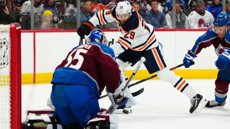 Mar 21, 2022; Denver, Colorado, USA; Edmonton Oilers center Leon Draisaitl (29) shoots the puck at Colorado Avalanche goaltender Darcy Kuemper (35) in the first period at Ball Arena. Mandatory Credit: Ron Chenoy-USA TODAY Sports