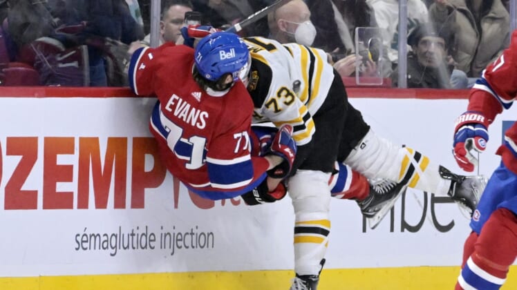 Mar 21, 2022; Montreal, Quebec, CAN; Boston Bruins defenseman Charlie McAvoy (73) upends Montreal Canadiens forward Jake Evans (71) during the third period at the Bell Centre. Mandatory Credit: Eric Bolte-USA TODAY Sports