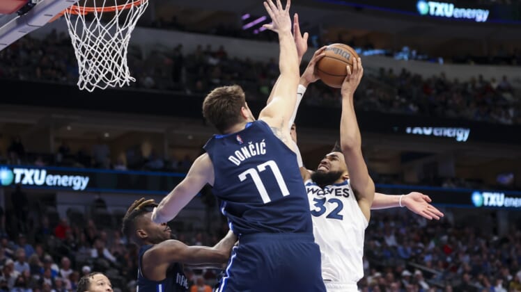 Mar 21, 2022; Dallas, Texas, USA;  Minnesota Timberwolves center Karl-Anthony Towns (32) shoots over Dallas Mavericks guard Luka Doncic (77) during the second half at American Airlines Center. Mandatory Credit: Kevin Jairaj-USA TODAY Sports