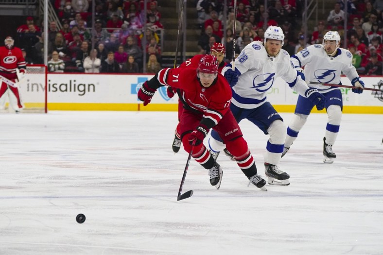 Mar 22, 2022; Raleigh, North Carolina, USA;  Carolina Hurricanes right wing Jesper Fast (71) and Tampa Bay Lightning defenseman Mikhail Sergachev (98) chase after the puck during the first period at PNC Arena. Mandatory Credit: James Guillory-USA TODAY Sports