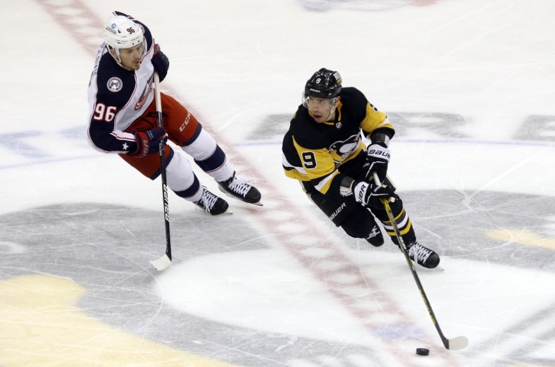 Mar 22, 2022; Pittsburgh, Pennsylvania, USA;  Pittsburgh Penguins center Evan Rodrigues (9) moves the puck against Columbus Blue Jackets center Jack Roslovic (96) during the second period at PPG Paints Arena. Mandatory Credit: Charles LeClaire-USA TODAY Sports
