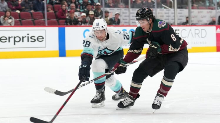 Mar 22, 2022; Glendale, Arizona, USA; Seattle Kraken defenseman Carson Soucy (28) and Arizona Coyotes center Nick Schmaltz (8) go after a loose puck during the first period at Gila River Arena. Mandatory Credit: Joe Camporeale-USA TODAY Sports