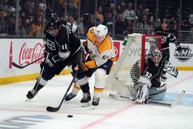 Mar 22, 2022; Los Angeles, California, USA; LA Kings center Anze Kopitar (11) and goaltender Jonathan Quick (32) defend against Nashville Predators center Mikael Granlund (64) during the first period at Crypto.com Arena. Mandatory Credit: Kirby Lee-USA TODAY Sports