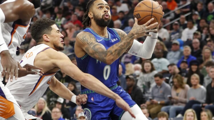 Mar 23, 2022; Minneapolis, Minnesota, USA; Minnesota Timberwolves guard D'Angelo Russell (0) moves past Phoenix Suns guard Devin Booker (1) to the basket in the first quarter at Target Center. Mandatory Credit: Bruce Kluckhohn-USA TODAY Sports