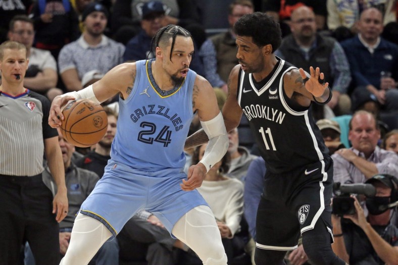 Mar 23, 2022; Memphis, Tennessee, USA; Memphis Grizzlies guard Dillon Brooks (24) dribbles toward the basket as Brooklyn Nets guard Kyrie Irving (11) defends during the first half at FedExForum. Mandatory Credit: Petre Thomas-USA TODAY Sports