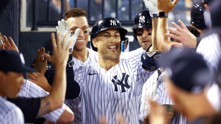 Mar 23, 2022; Tampa, Florida, USA; New York Yankees designated hitter Giancarlo Stanton (27) is congratulated after he hit a two-run home run during the fifth inning against the Baltimore Orioles during spring training at George M. Steinbrenner Field. Mandatory Credit: Kim Klement-USA TODAY Sports