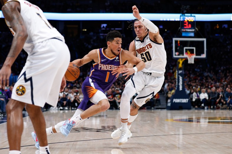Mar 24, 2022; Denver, Colorado, USA; Phoenix Suns guard Devin Booker (1) drives to the net against Denver Nuggets forward Aaron Gordon (50) in the second quarter at Ball Arena. Mandatory Credit: Isaiah J. Downing-USA TODAY Sports