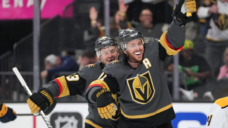 Mar 24, 2022; Las Vegas, Nevada, USA; Vegas Golden Knights right wing Evgenii Dadonov (63) and center Jonathan Marchessault (81) celebrate after Vegas Golden Knights center Jack Eichel (not pictured) scored a goal against the Nashville Predators during the second period at T-Mobile Arena. Mandatory Credit: Stephen R. Sylvanie-USA TODAY Sports