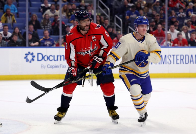 Mar 25, 2022; Buffalo, New York, USA;  Washington Capitals left wing Alex Ovechkin (8) and Buffalo Sabres defenseman Henri Jokiharju (10) look for the puck during the first period at KeyBank Center. Mandatory Credit: Timothy T. Ludwig-USA TODAY Sports