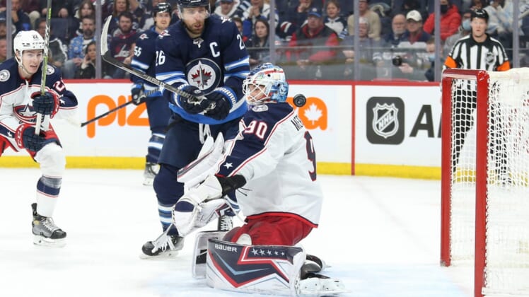 Mar 25, 2022; Winnipeg, Manitoba, CAN;  Winnipeg Jets defenseman Josh Morrissey (44) (not shown) scores on Columbus Blue Jackets goalie Elvis Merzlikins (90) during the first period at Canada Life Centre. Mandatory Credit: Terrence Lee-USA TODAY Sports