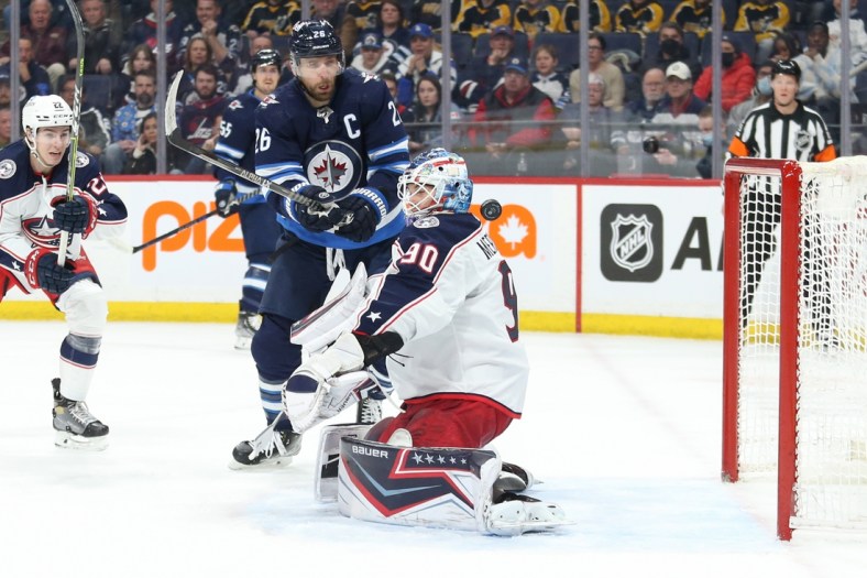 Mar 25, 2022; Winnipeg, Manitoba, CAN;  Winnipeg Jets defenseman Josh Morrissey (44) (not shown) scores on Columbus Blue Jackets goalie Elvis Merzlikins (90) during the first period at Canada Life Centre. Mandatory Credit: Terrence Lee-USA TODAY Sports
