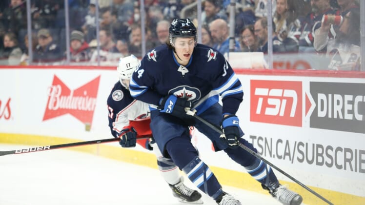 Mar 25, 2022; Winnipeg, Manitoba, CAN;  Winnipeg Jets defenseman Logan Stanley (64) skates away from Columbus Blue Jackets forward Justin Danforth (17) during the first period at Canada Life Centre. Mandatory Credit: Terrence Lee-USA TODAY Sports