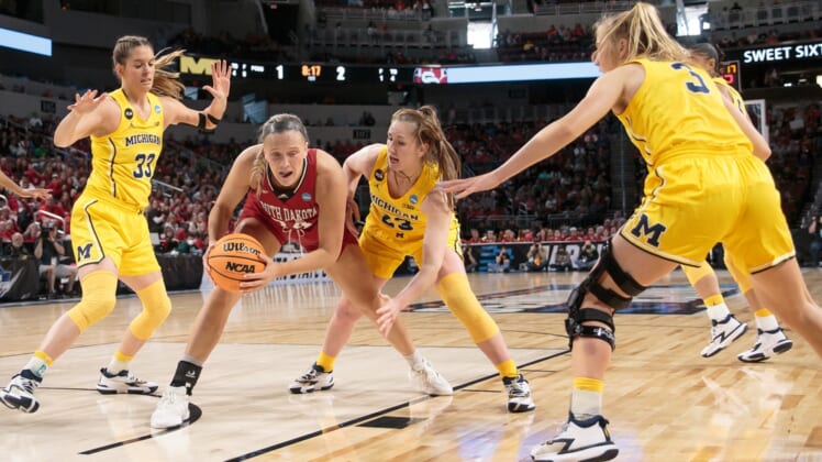 Mar 26, 2022; Wichita, KS, USA; South Dakota Coyotes center Hannah Sjerven (34) controls the ball against Michigan Wolverines center Brooklyn Rewers (23) during the Wichita regional semifinals of the women's college basketball NCAA Tournament at INTRUST Bank Arena. Mandatory Credit: William Purnell-USA TODAY Sports