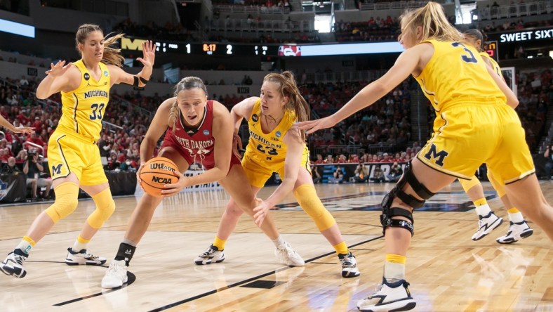 Mar 26, 2022; Wichita, KS, USA; South Dakota Coyotes center Hannah Sjerven (34) controls the ball against Michigan Wolverines center Brooklyn Rewers (23) during the Wichita regional semifinals of the women's college basketball NCAA Tournament at INTRUST Bank Arena. Mandatory Credit: William Purnell-USA TODAY Sports