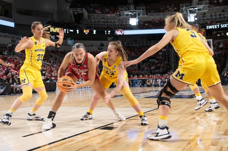 Mar 26, 2022; Wichita, KS, USA; South Dakota Coyotes center Hannah Sjerven (34) controls the ball against Michigan Wolverines center Brooklyn Rewers (23) during the Wichita regional semifinals of the women's college basketball NCAA Tournament at INTRUST Bank Arena. Mandatory Credit: William Purnell-USA TODAY Sports