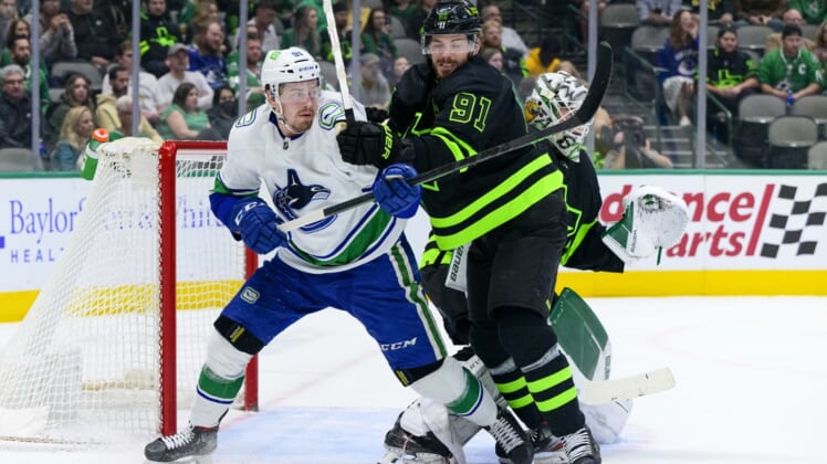 Mar 26, 2022; Dallas, Texas, USA; Dallas Stars center Tyler Seguin (91) defends against Vancouver Canucks left wing Juho Lammikko (91) during the first period at the American Airlines Center. Mandatory Credit: Jerome Miron-USA TODAY Sports