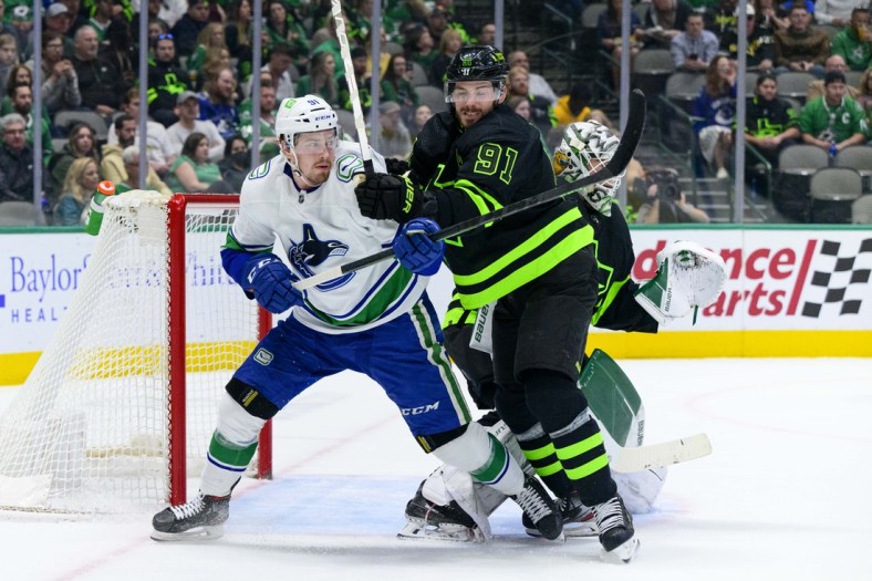 Mar 26, 2022; Dallas, Texas, USA; Dallas Stars center Tyler Seguin (91) defends against Vancouver Canucks left wing Juho Lammikko (91) during the first period at the American Airlines Center. Mandatory Credit: Jerome Miron-USA TODAY Sports