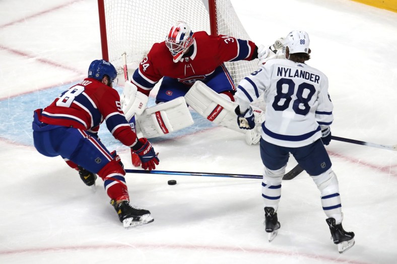 Mar 26, 2022; Montreal, Quebec, CAN; Montreal Canadiens defenseman David Savard (58) assists goaltender Jake Allen (34) with a save against Toronto Maple Leafs right wing William Nylander (88) during the first period at Bell Centre. Mandatory Credit: Jean-Yves Ahern-USA TODAY Sports